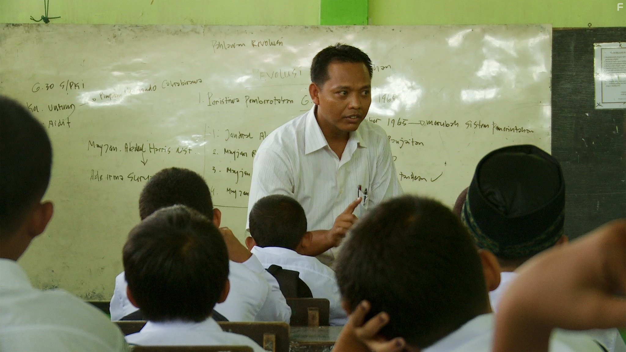 A teacher propagates the existing rhetoric on the Indonesian genocide to his pupils.