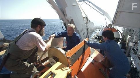 MIR crew members help James Cameron (center) into MIR 1.