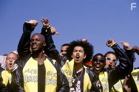 Kid (DEREK LUKE, front left) and Primo (RICK GONZALEZ, front right) and the rest of the Biker Boyz cheer on another racer.