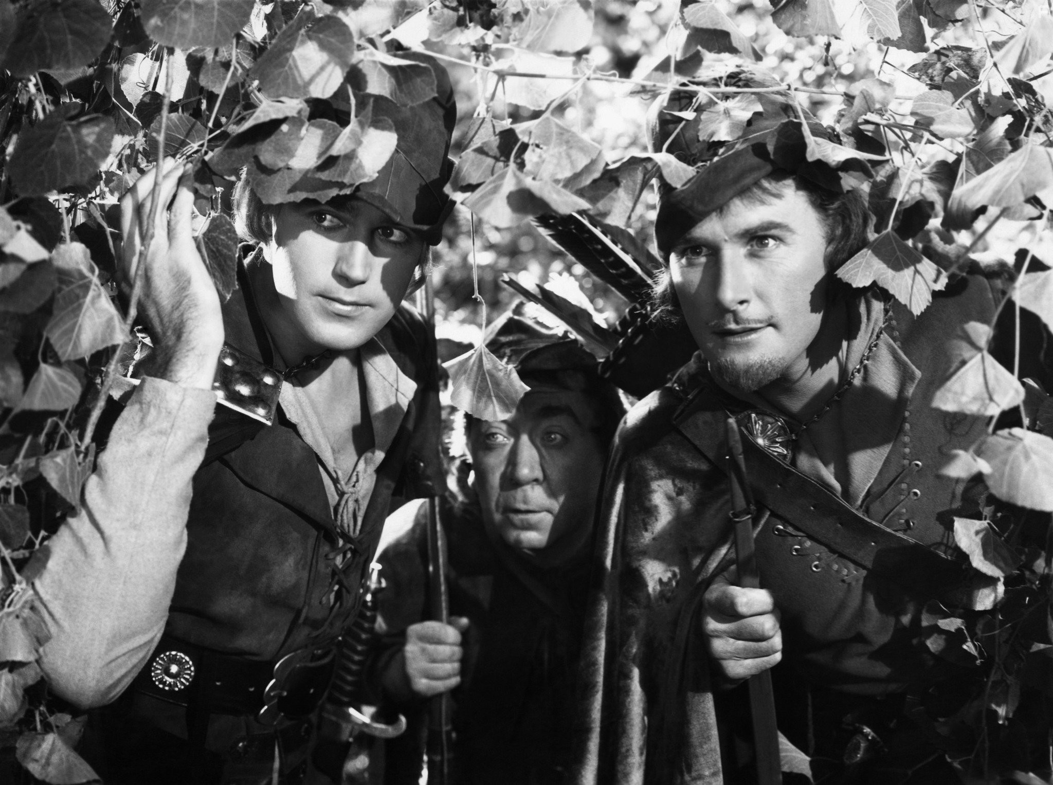 Errol Flynn, Patric Knowles, and Herbert Mundin in Приключения Робин Гуда (1938)