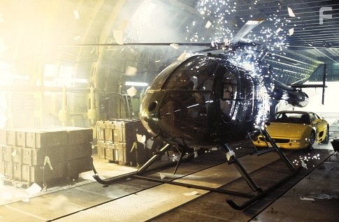 Sparks rain down on a helicopter while the cargo plane carrying it disintegrates.