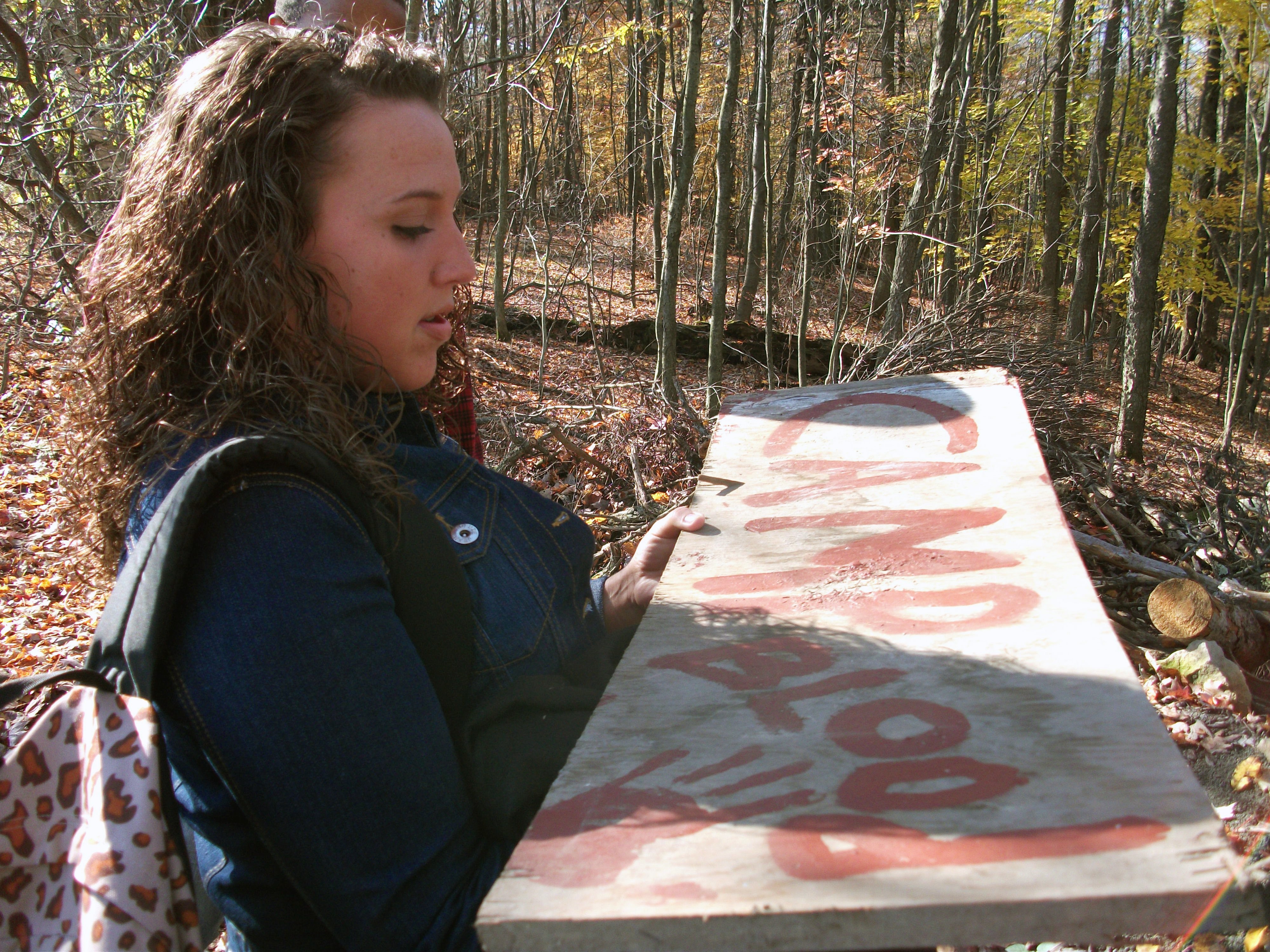 Kelsey Kaufmann as a student who finds an old Camp Blood sign.